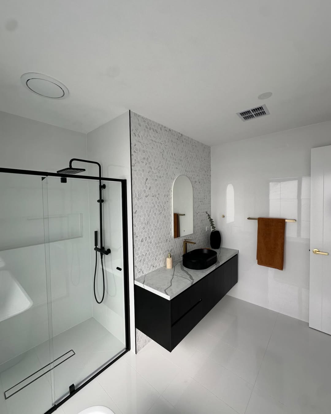 Bathroom with hexagon mosaic and black shower frame